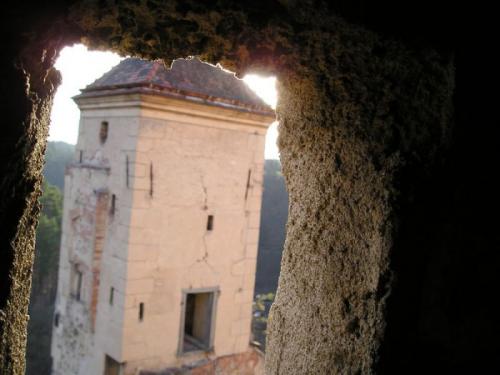 Pohled skrze okénko na&nbsp;věž na&nbsp;konci hradu